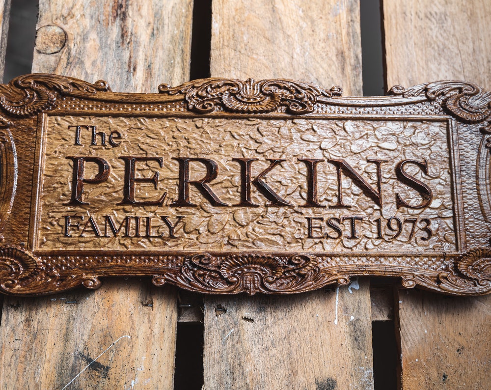 custom carved family name sign with established date, intricate frame and textured background by MrGoodWoodCNC